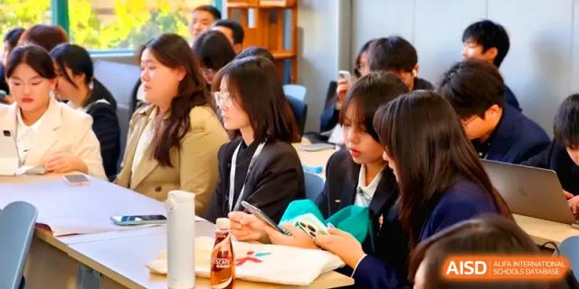 Female students in formal blazers sit at a table participating in a meeting or academic discussion at Zhengzhou No.11 High School.