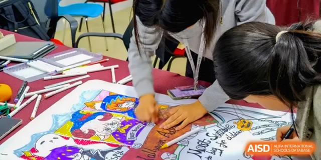 Students work together on a large, colorful poster filled with creative drawings and text for a project at Zhengzhou No.11 High School.
