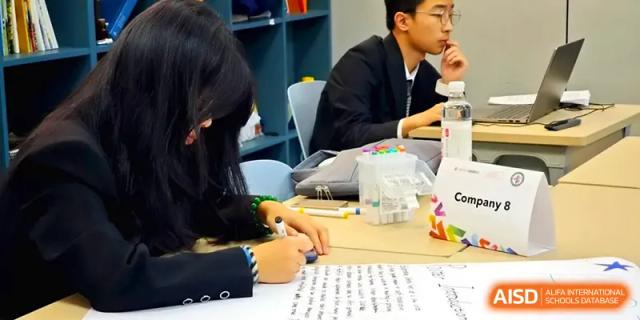 Close-up of a student in a dark blazer writing diligently on a worksheet during a structured class period at Zhengzhou No.11 High School.
